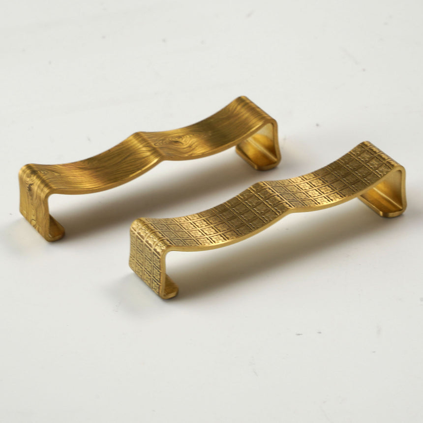 Brass bent cutlery rest with wood grain pattern